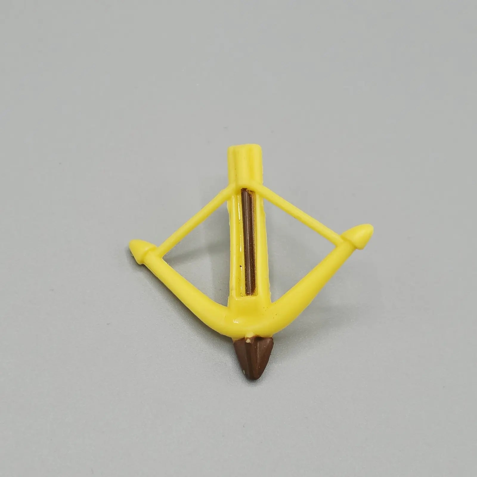 Yellow plastic archery bow stand on a gray background