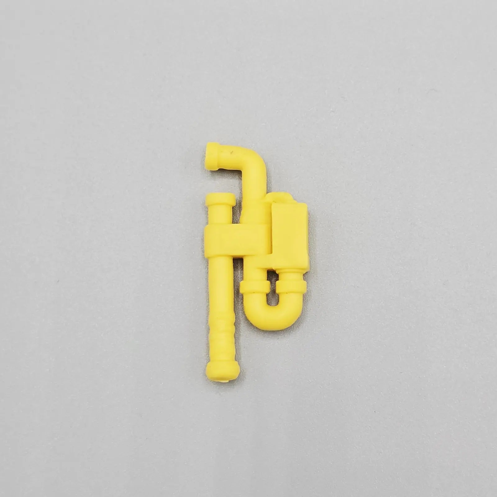 Yellow plastic component on a gray background