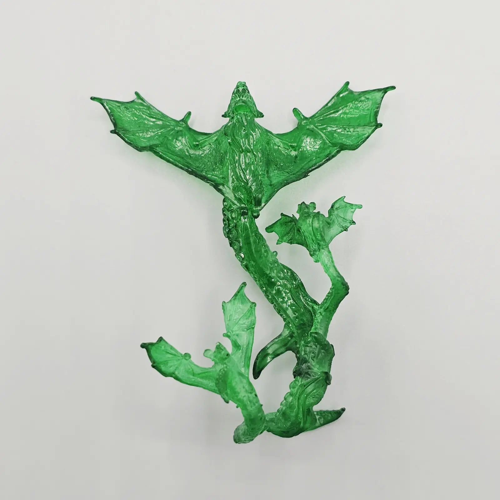 Green bat figurine on a light gray background