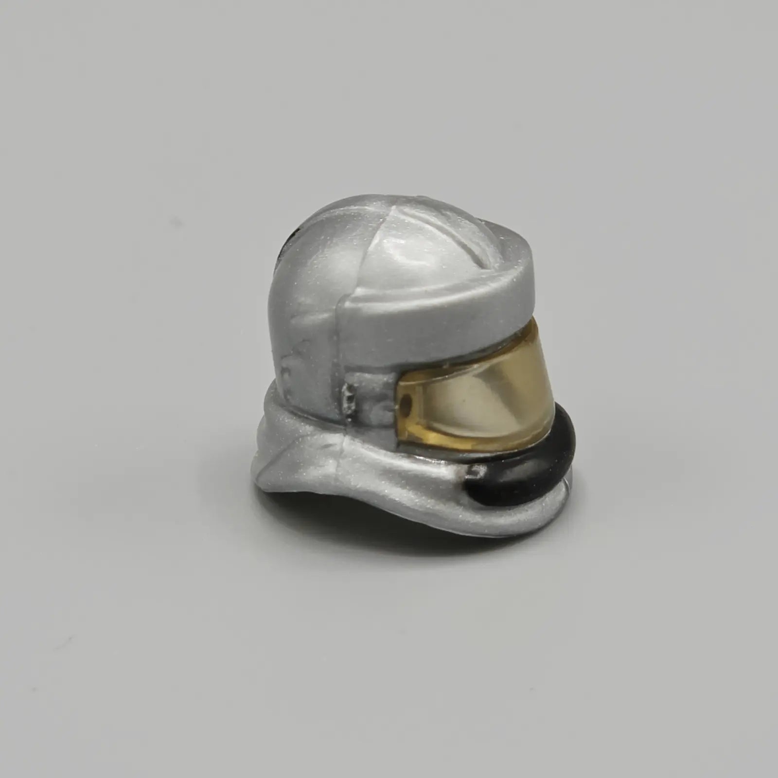 Metallic helmet-shaped object on a gray background