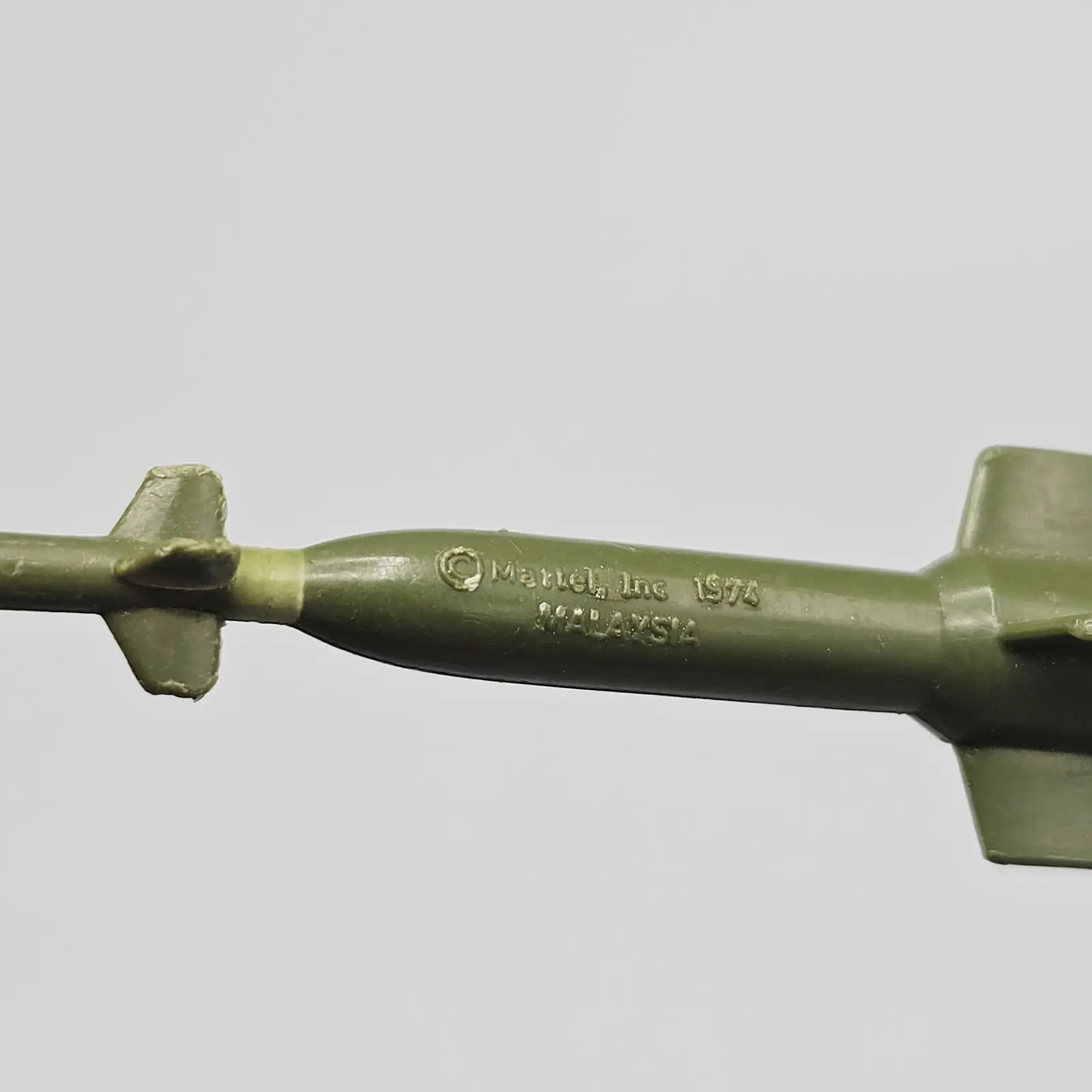 Up close shot of green missile branded "Mattel, Inc 1974 Malaysia"