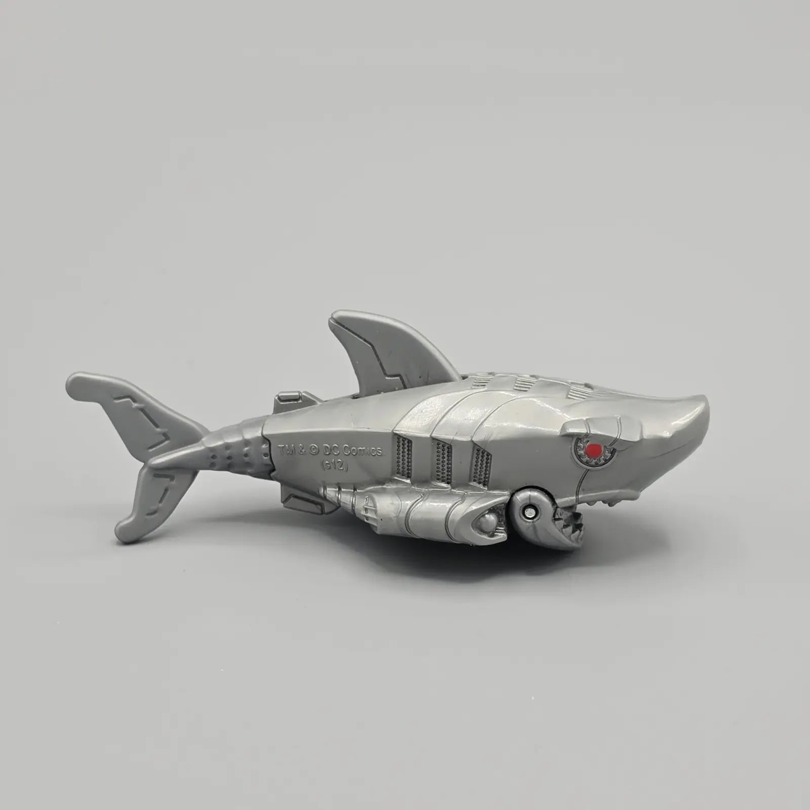 Toy shark with a metallic finish on a gray background