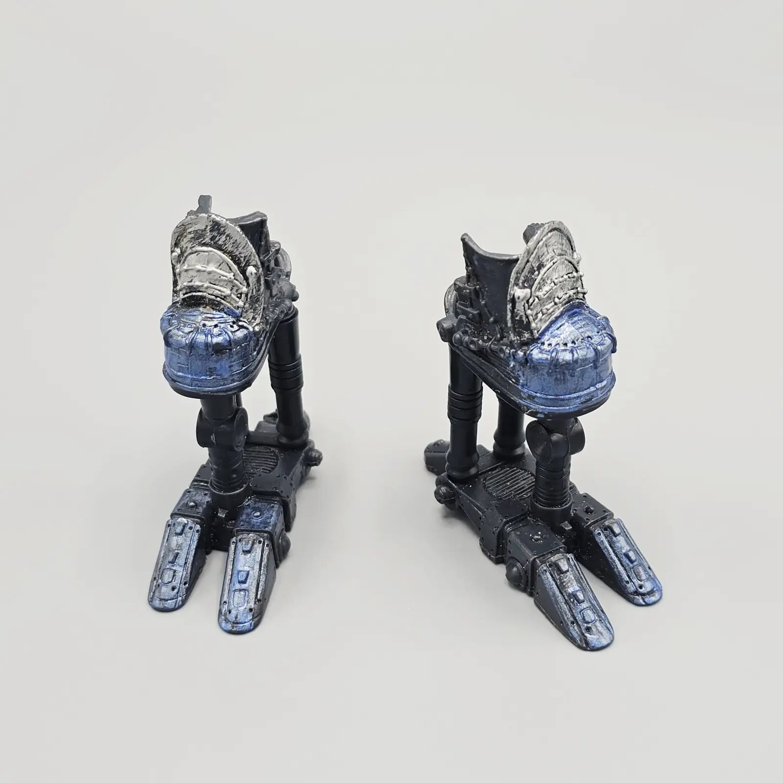 Pair of futuristic robot feet on a light gray background
