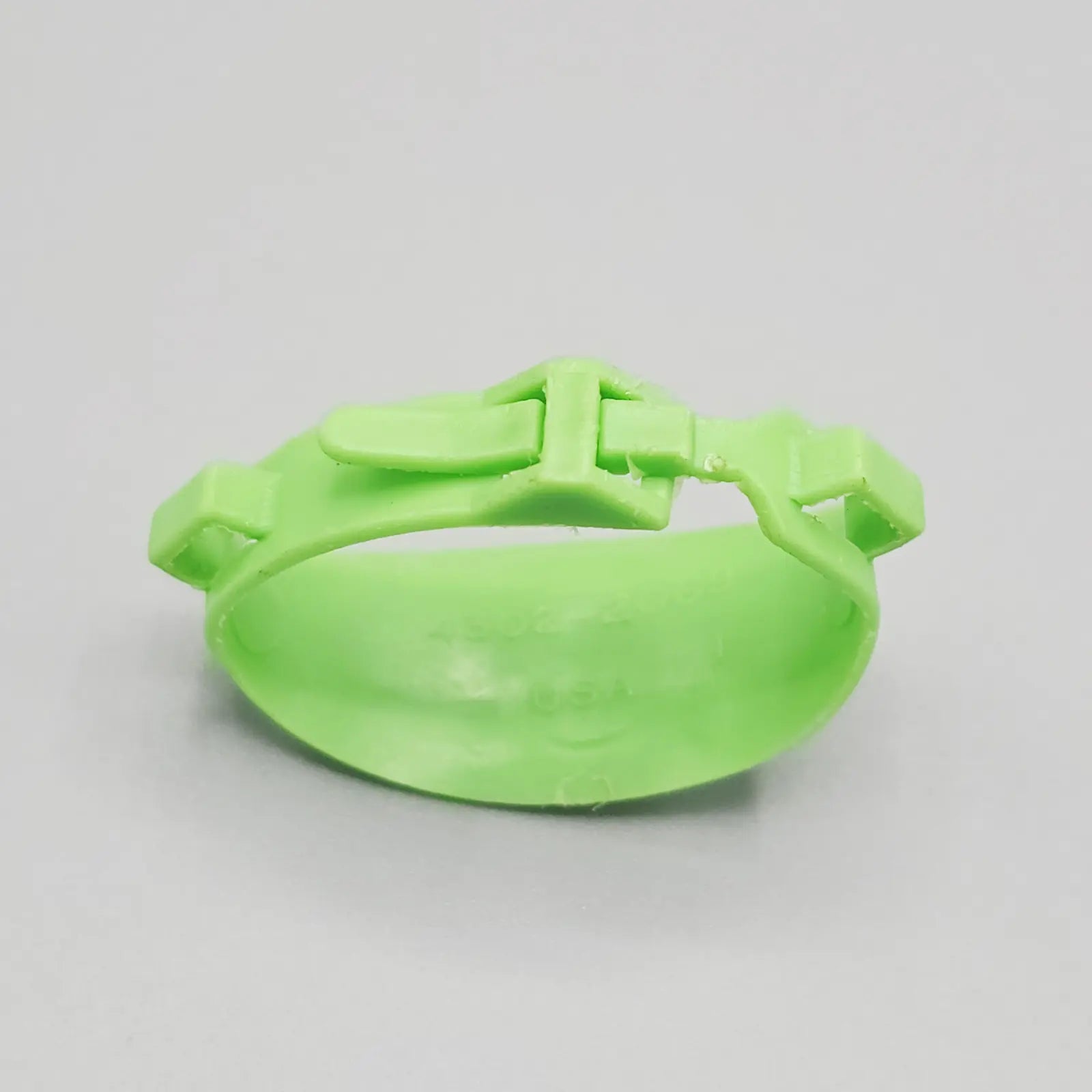 Green action figure belt on a gray background