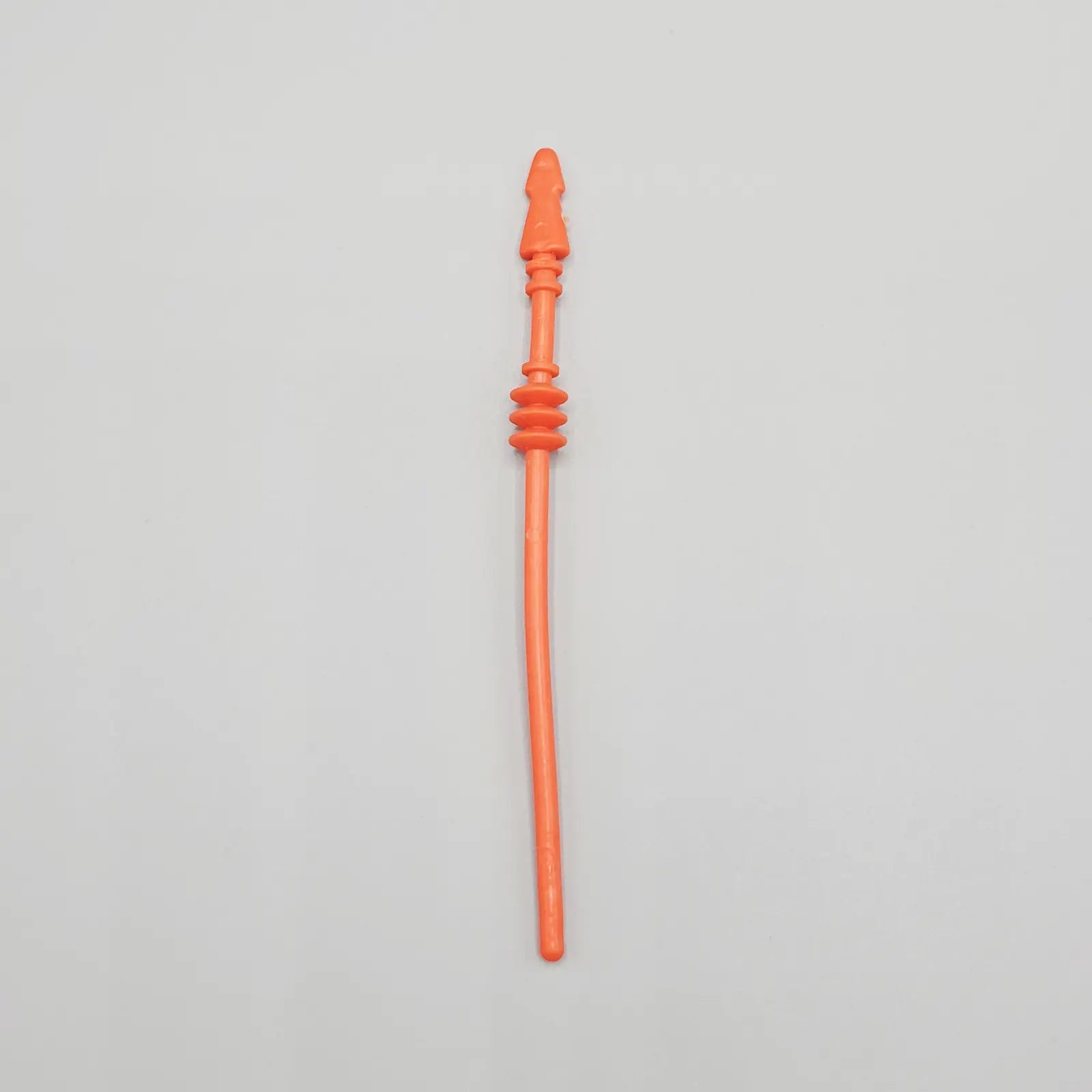 Orange action figure spear on a gray background