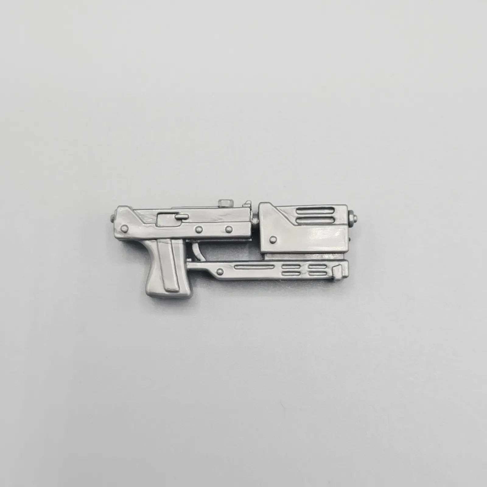 Metallic futuristic gun-shaped object on a gray background