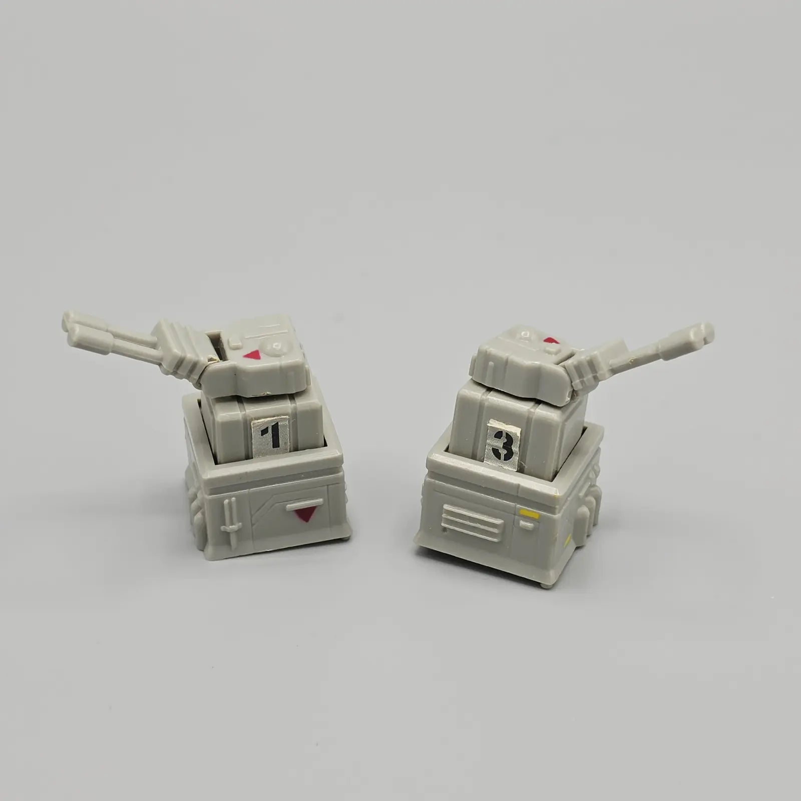 Two toy tank models on a gray background