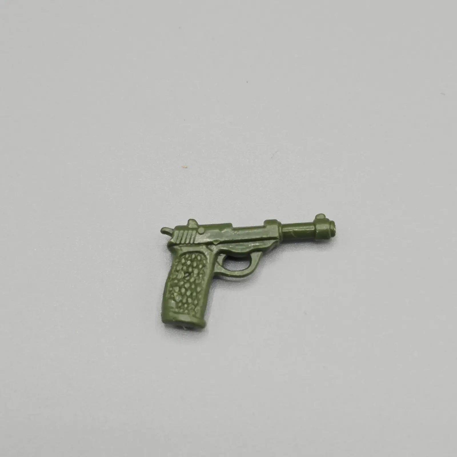 Green toy gun on a light gray background