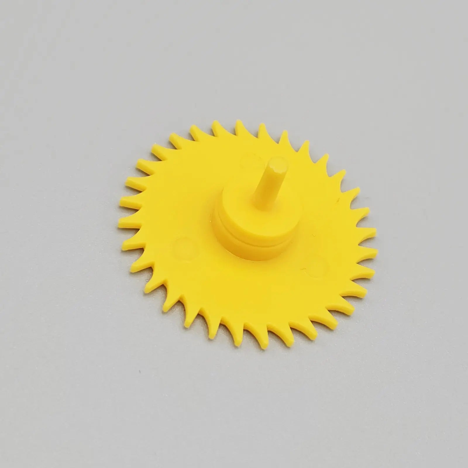 Yellow plastic component on a gray background