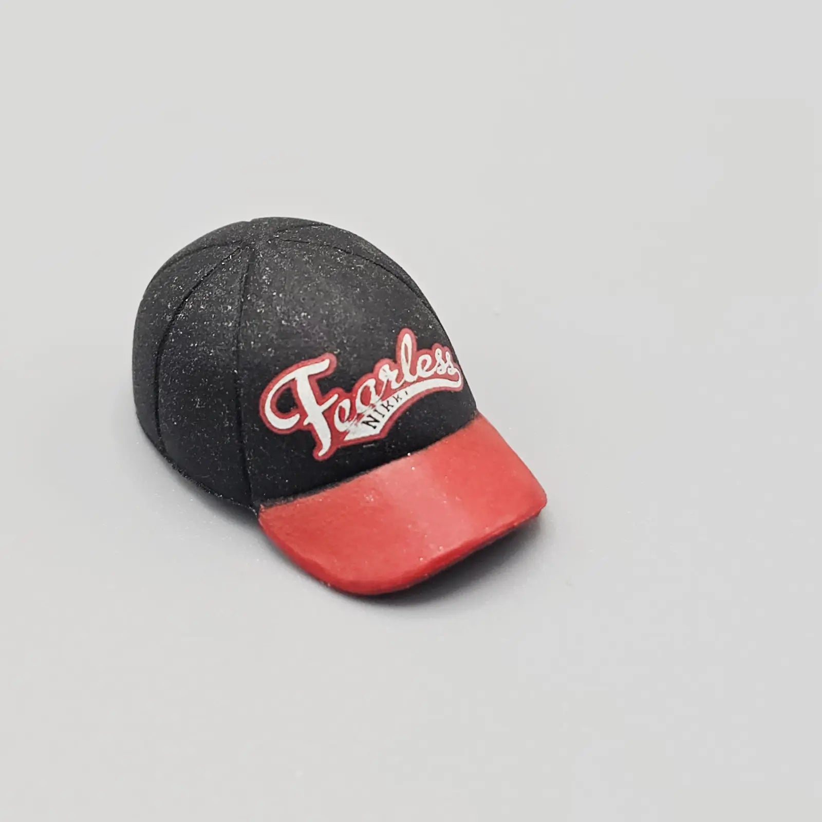 Black and red cap with 'Fearless' text on a gray background