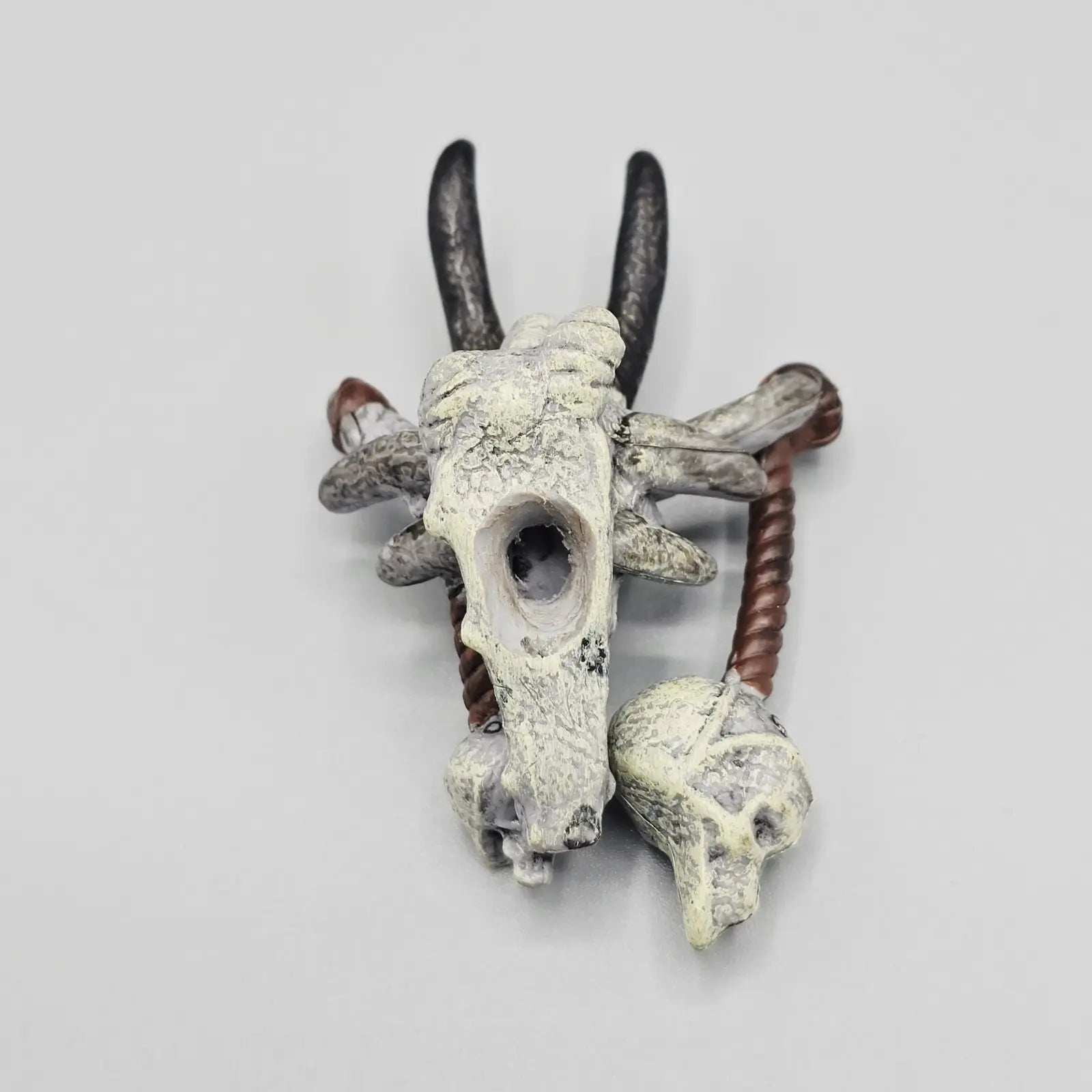 Decorative wall piece with a skull and antlers on a gray background